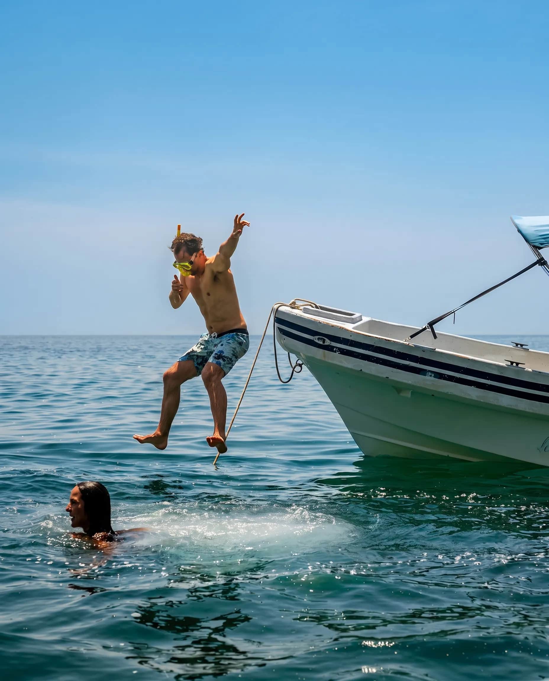 Niño saltando al mar desde una lancha